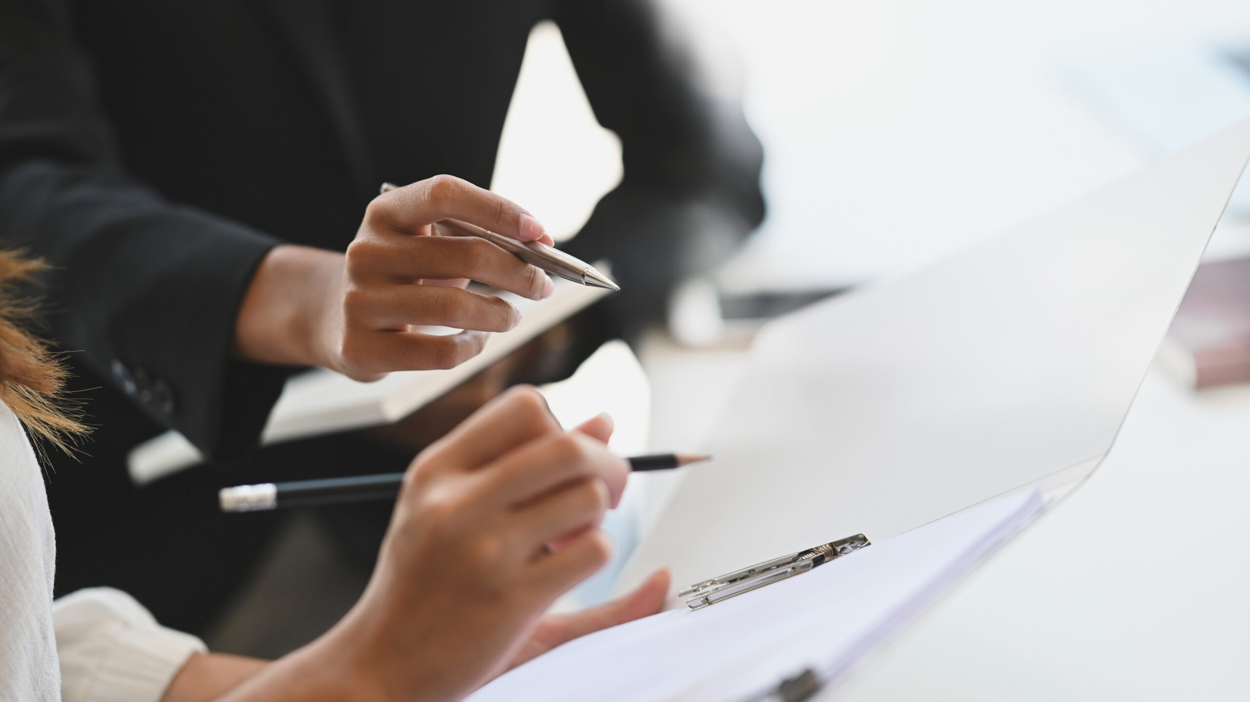 Closeup two woman consulting with paperwork document report.