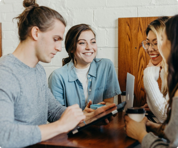 Group of people at work talking at a table with ipads.