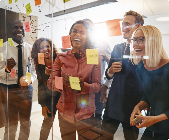 Photo of employees laughing while brainstorming.